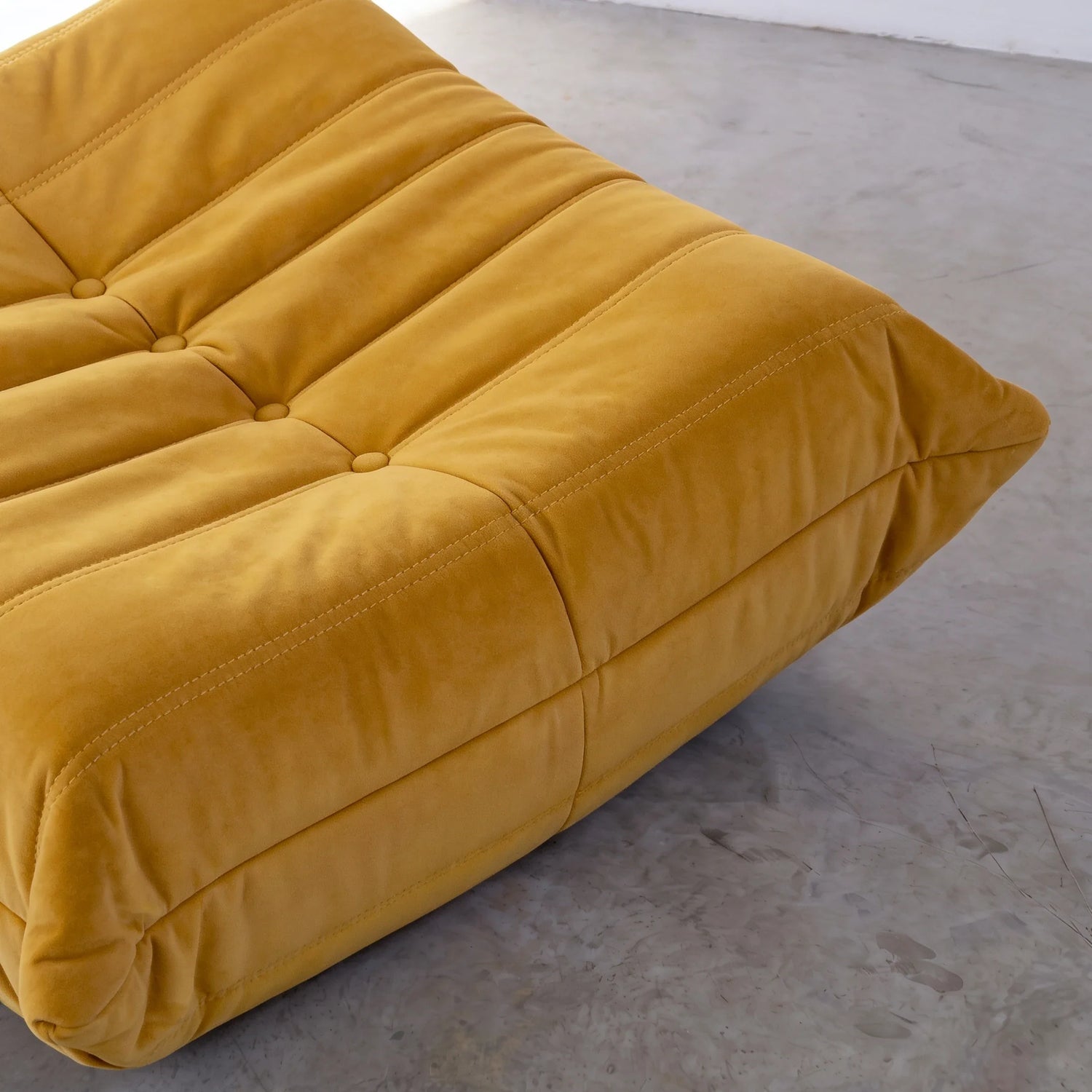 togo sofa dupe ottoman close-up showing the yellow velvet upholstery and tufted stitching by vibehaus