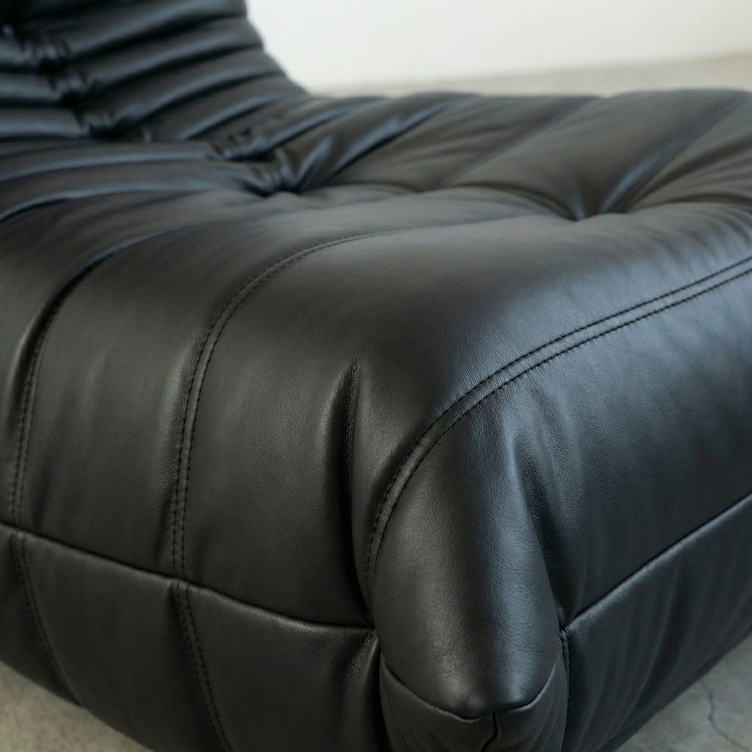 Close up of the Togo Chair dupe in black faux leather by vibehaus