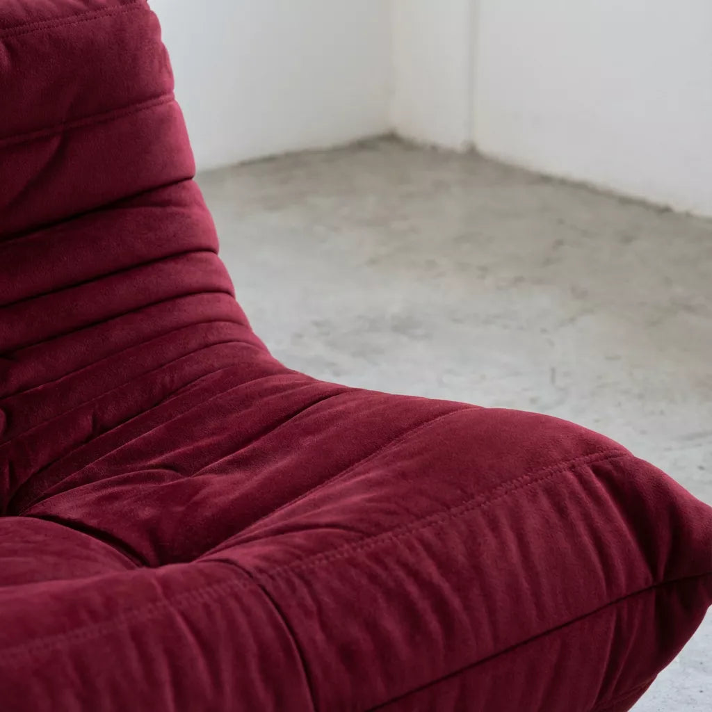 Close-up of a burgundy togo chair replica with a plain background by vibehaus