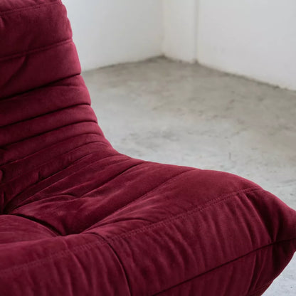 Close-up of a burgundy togo chair replica with a plain background by vibehaus