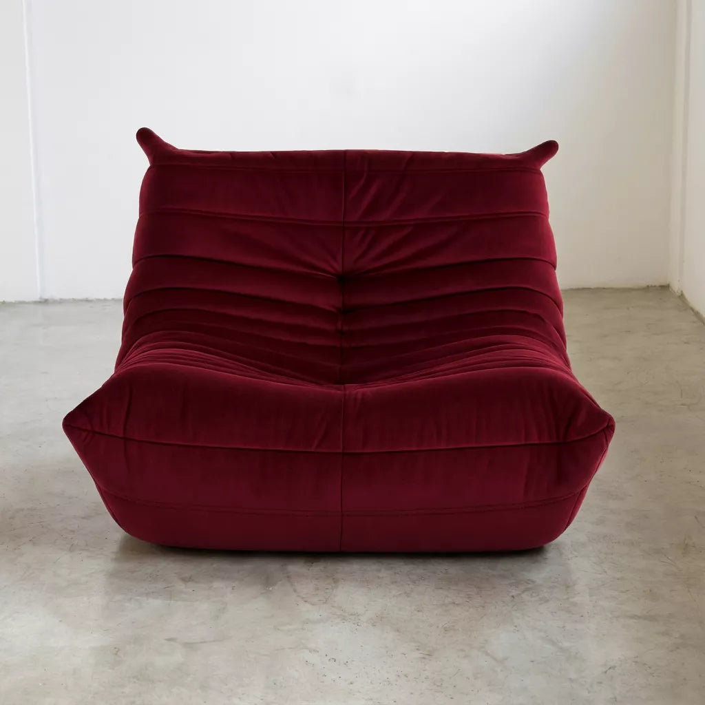 Replica of the burgundy velvet Togo-chair by michael ducaroy–  low, frameless design with plush channel tufting