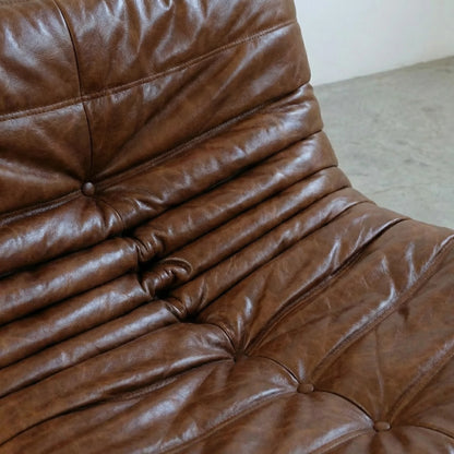 Close-up of a brown togo sofa dupe in leather with visible stitching