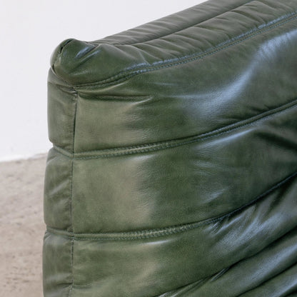Close-up of the green leather togo couch dupe with visible stitching on a neutral background