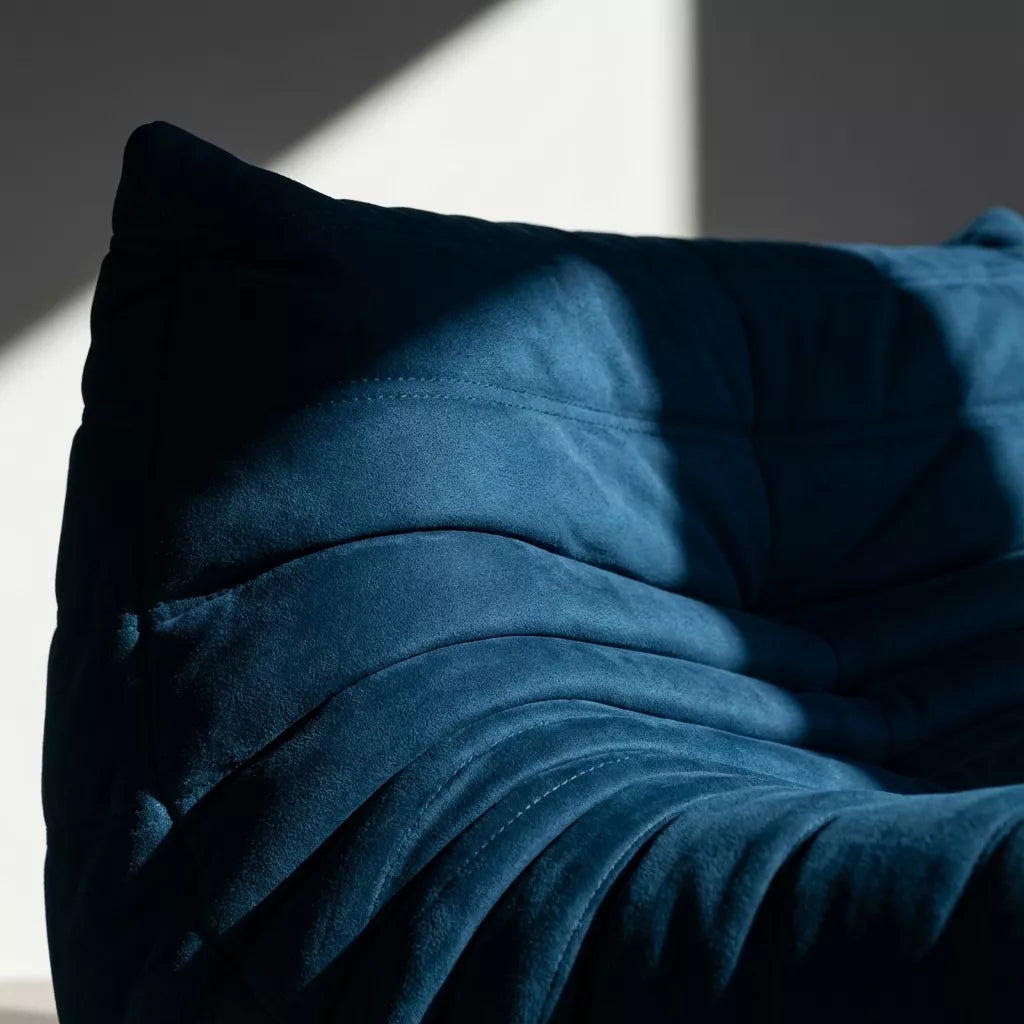 Replica of the dark blue velvet Togo-chair by michael ducaroy–  low, frameless design with plush channel tufting