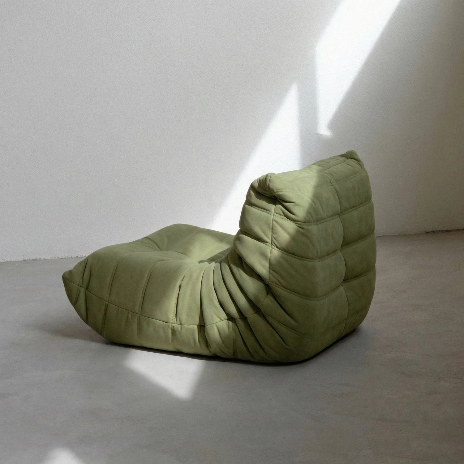 Togo Chair dupe in green velvet suede on concrete floor by vibehaus