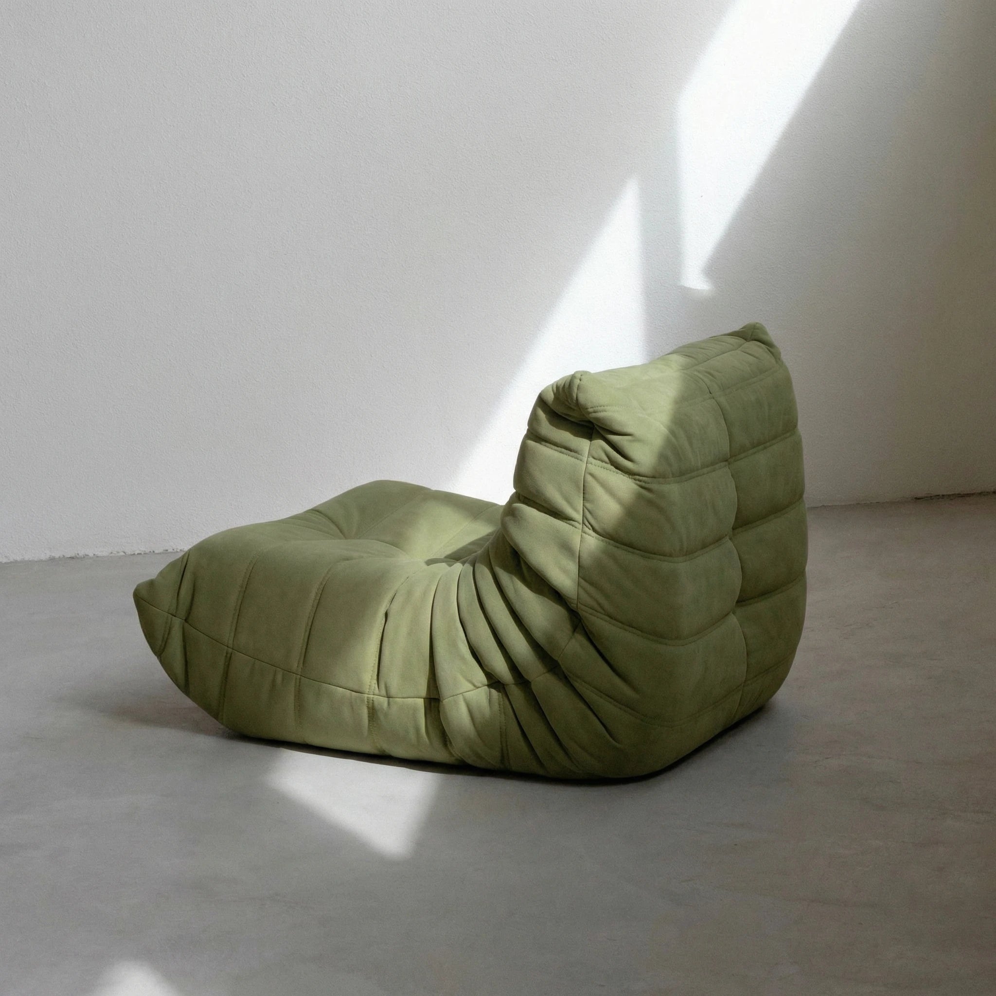Togo Chair dupe in green velvet suede on concrete floor by vibehaus