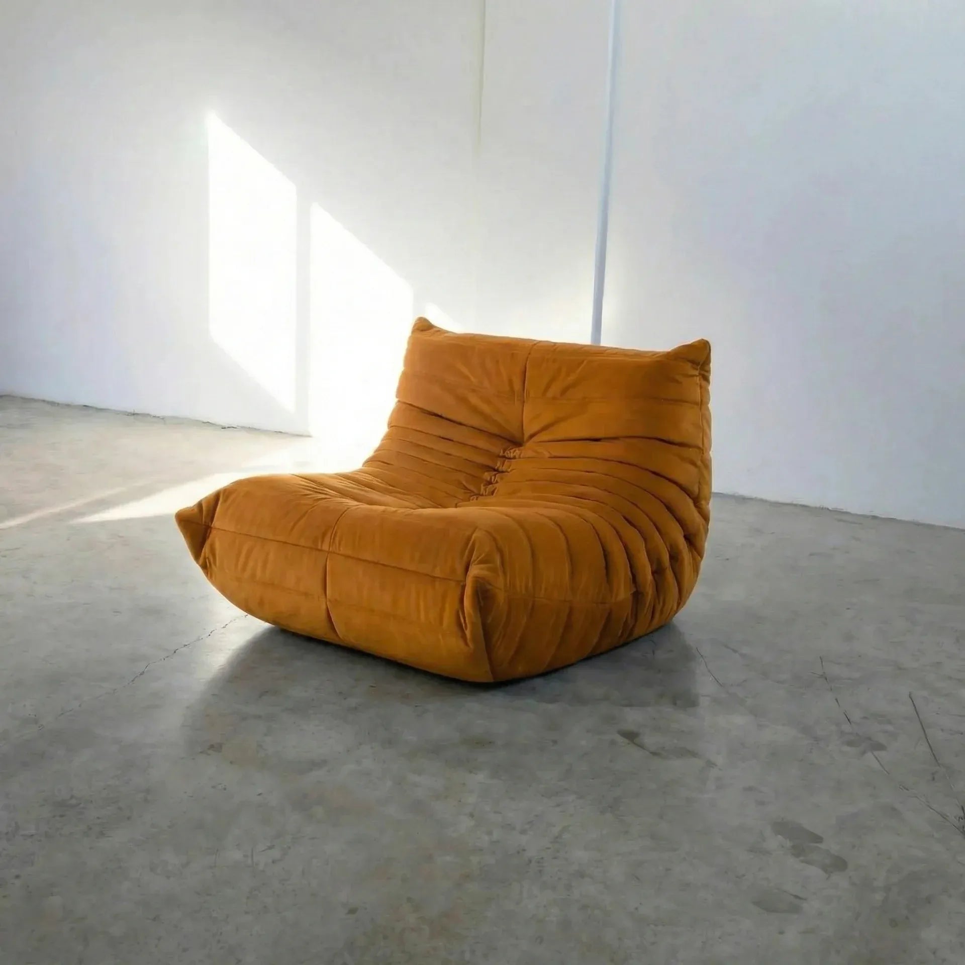 Mustard yellow togo chair dupe on a concrete floor with white walls by vibehaus
