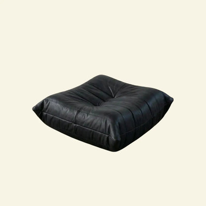 Black real leather togo pouf dupe on a beige background