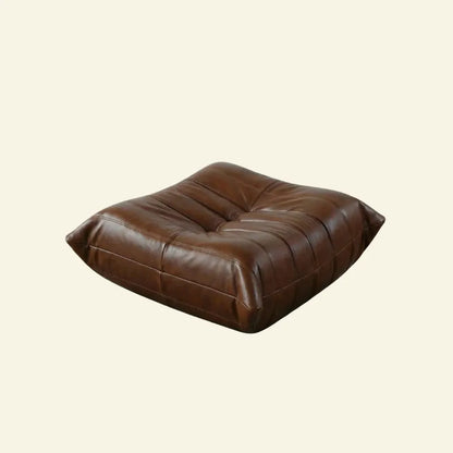 Brown togo leather ottoman dupe on a beige background