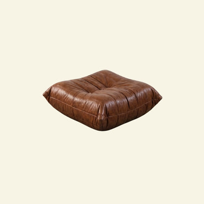 Brown togo leather ottoman dupe on a beige background