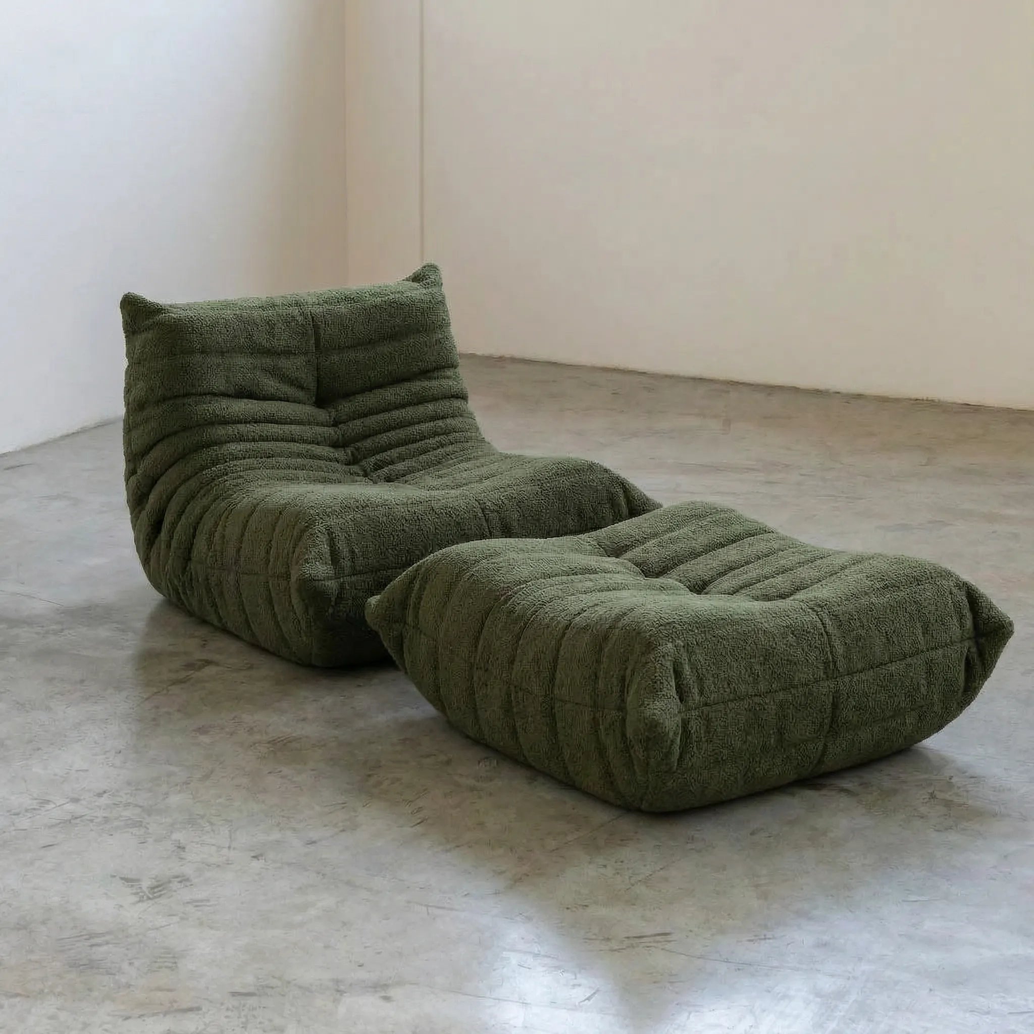 Togo chair and ottoman dupe in Dark Green Bouclé by Vibehaus on a concrete floor