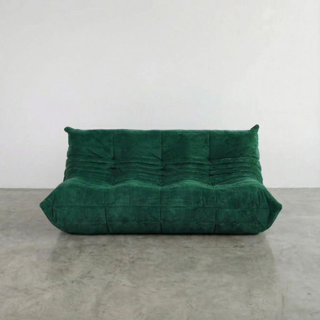 Togo 3 seater sofa dupe in dark green Corduroy by vibehaus on a concrete floor, photographed from a front angle.