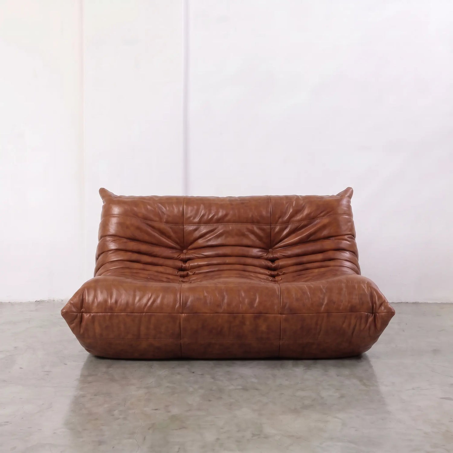 Brown togo sofa dupe in leather in a studio setting