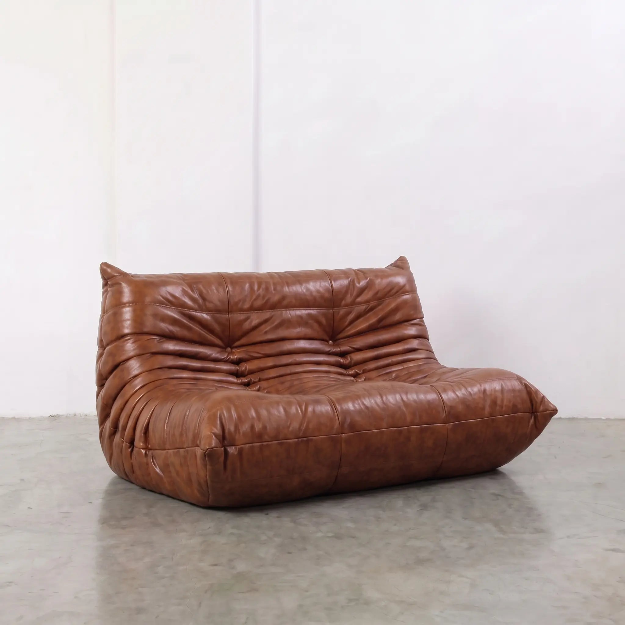 Brown togo sofa dupe in leather in a studio setting