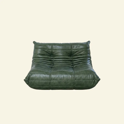 Green togo sofa dupe in leather on a light beige background