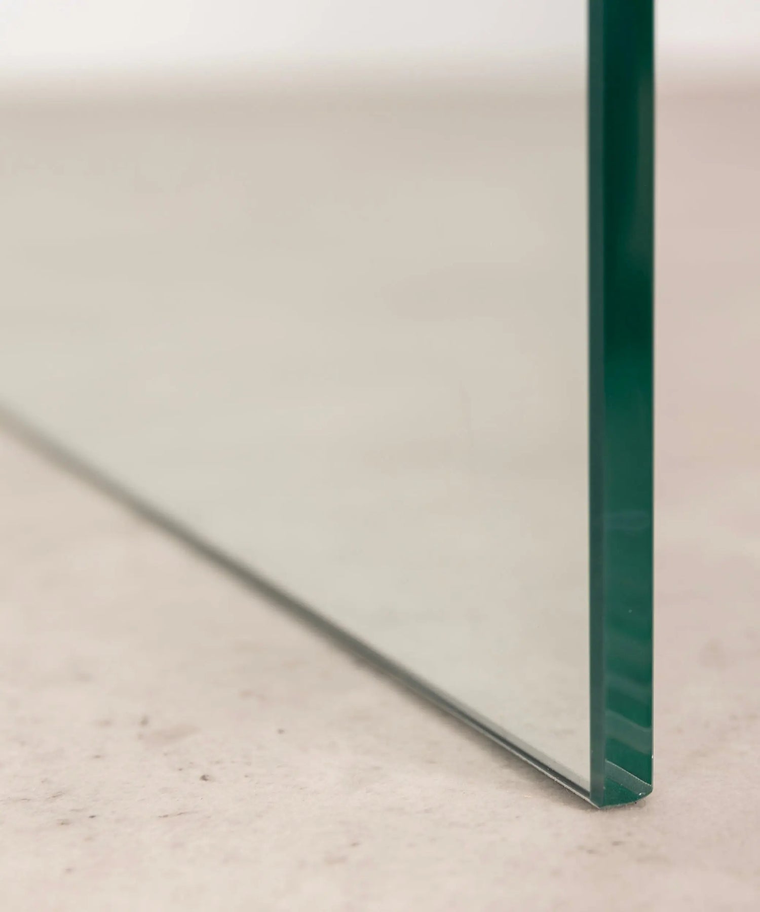 Close-up of the transparent  c-shaped side table against a neutral background