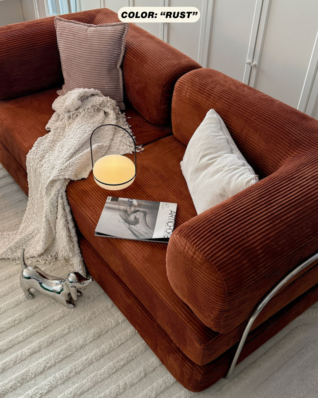 rust corduroy sofa with cushions and a lamp in a living room setting