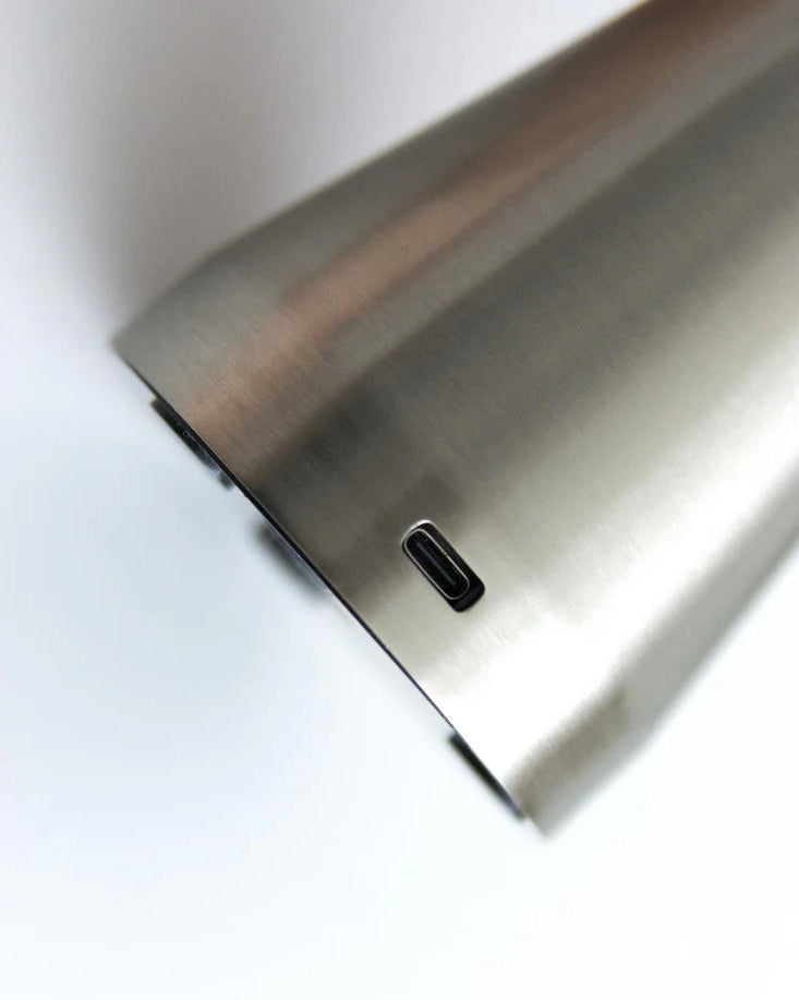 Close-up of a metallic surface of the velo chrome mushroom metal table lamp with a USB-C port on a white background