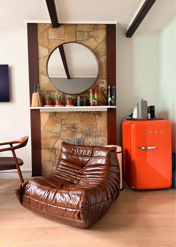 Brown quilted lounge chair beside a red cabinet in a living room.