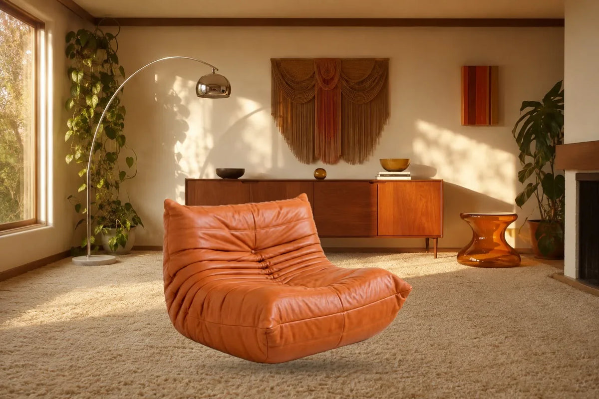 Cognac quilted lounge chair in a retro living room with a wooden sideboard and arc floor lamp.
