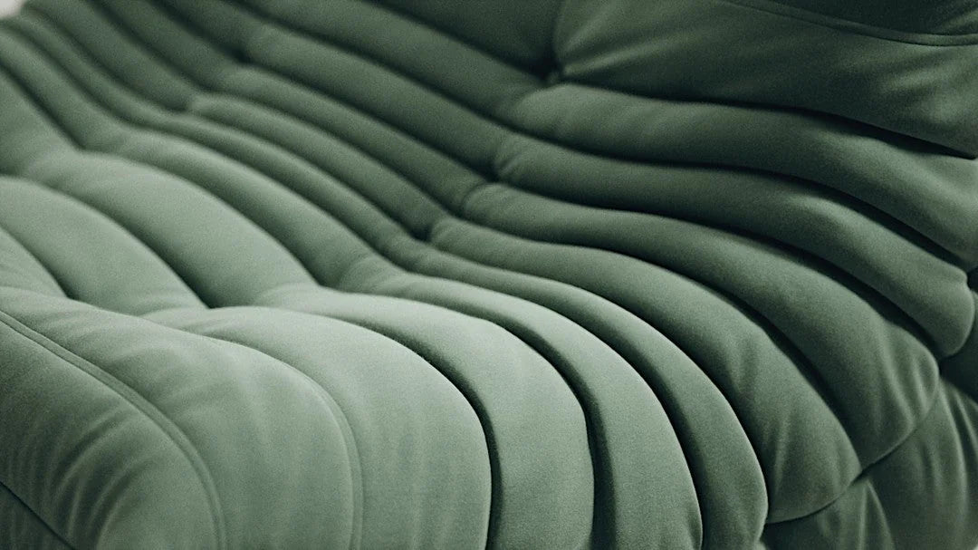 Close-up of green upholstery and quilting on a lounge chair.