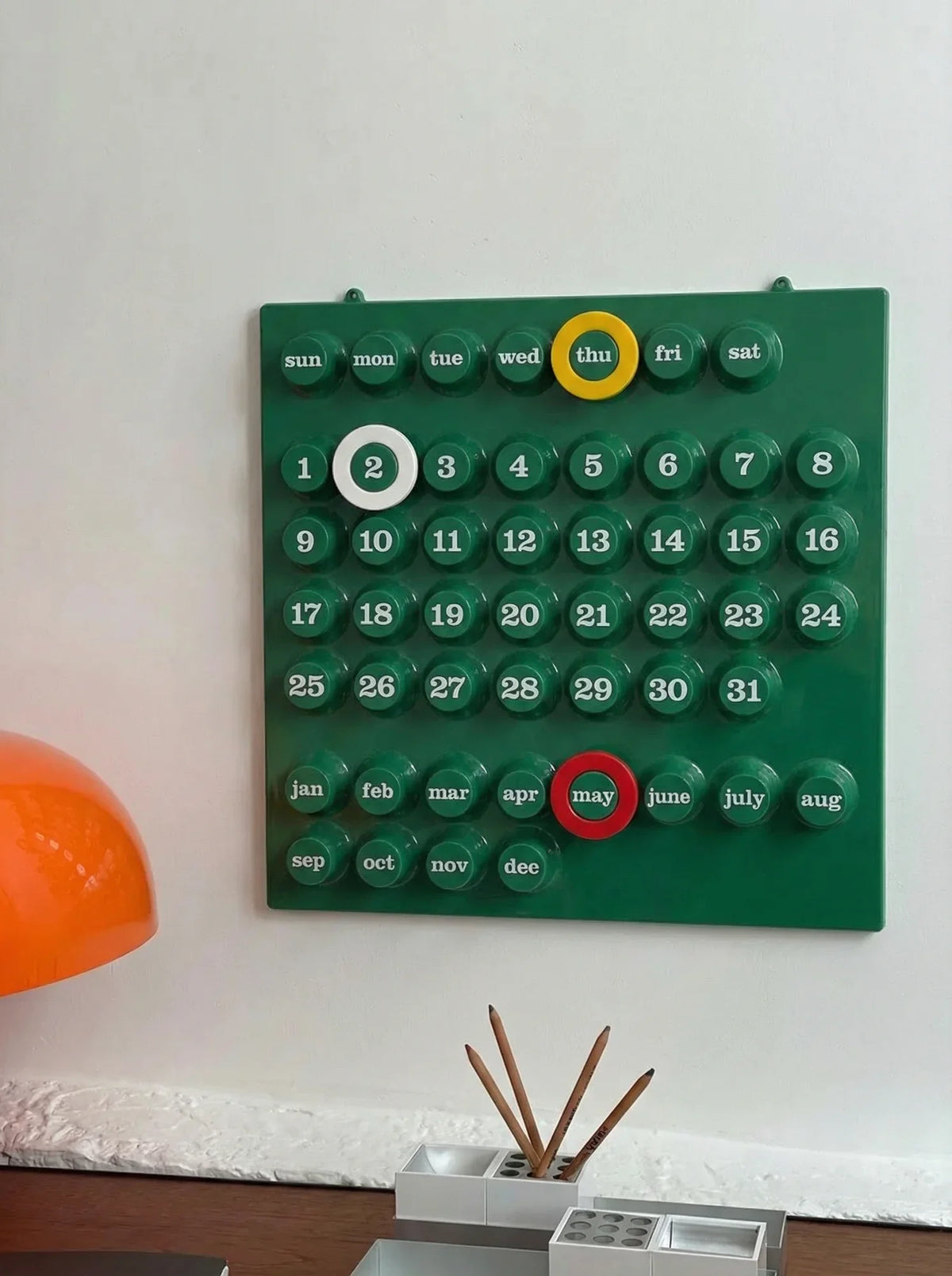 Green Ring-A-Date inspired wall calendar with yellow and red date markers.