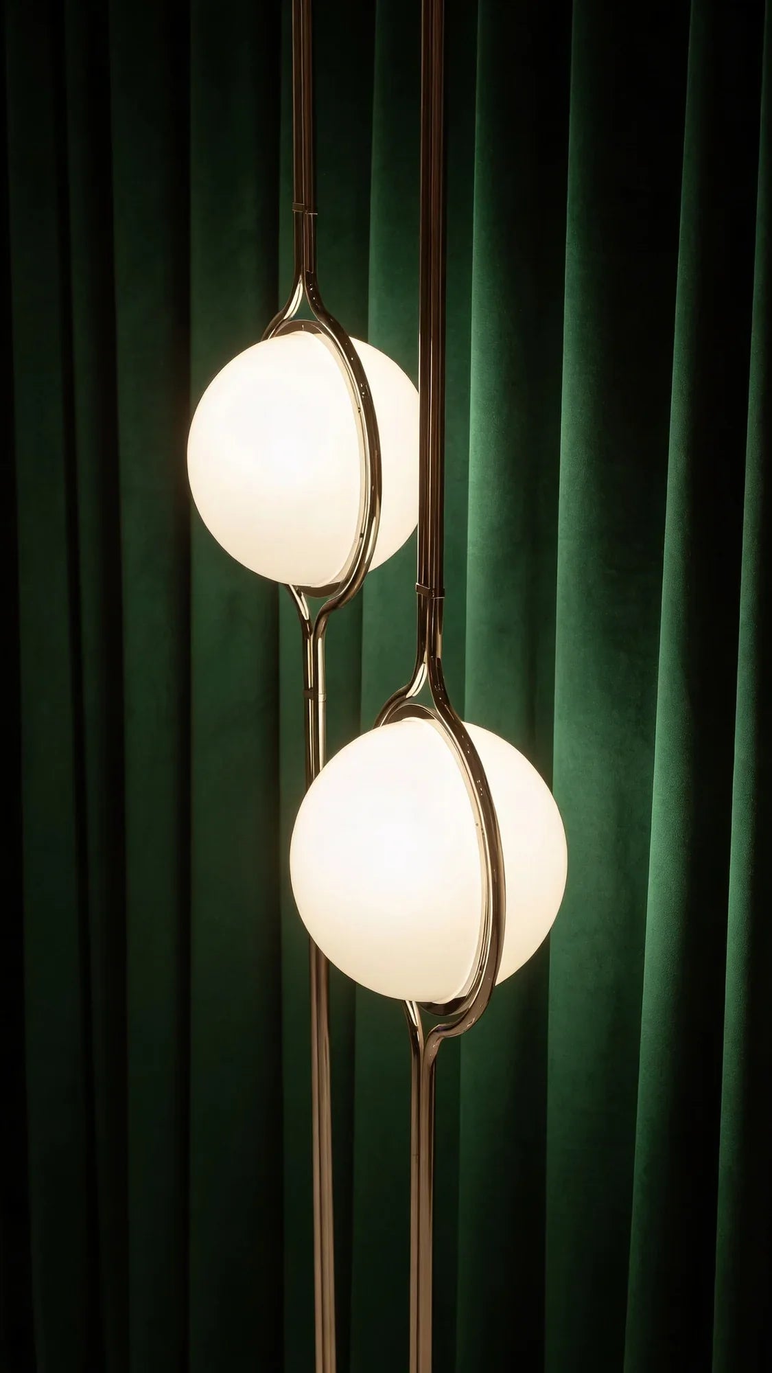 Zuru floor-to-ceiling lamp with two glowing globes against green curtains.