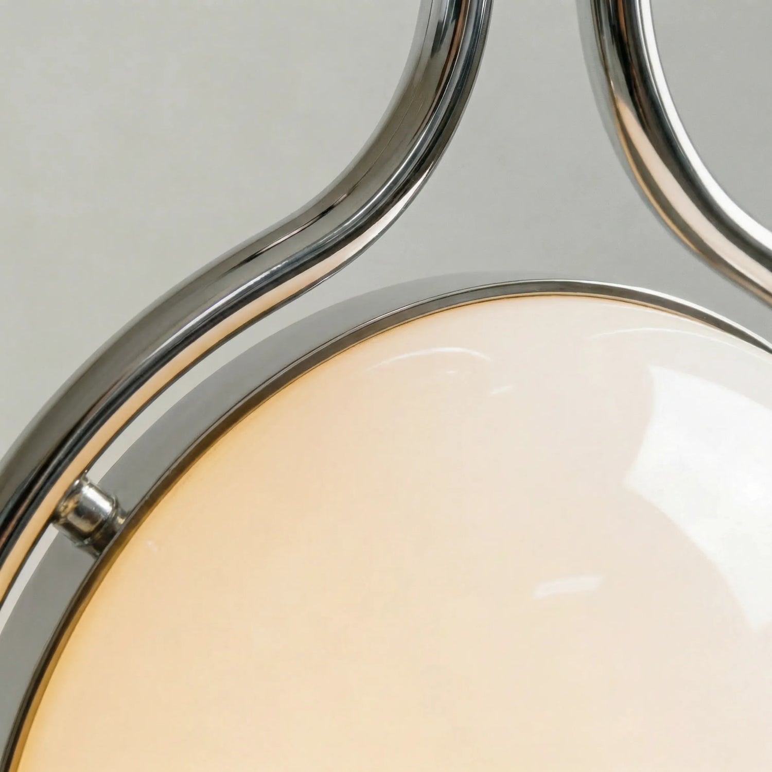 zuru floor to ceiling lamp close-up of chrome frame curves around the lit frosted globe