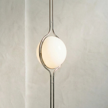 zuru floor to ceiling lamp side close-up of lit frosted globe and chrome frame on textured wall